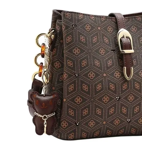 Detalhe lateral da bolsa transversal Chenson café com alça ajustável e chaveiro ursinho